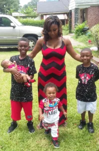Angel Latrice Burrell stands outside with her four young children.