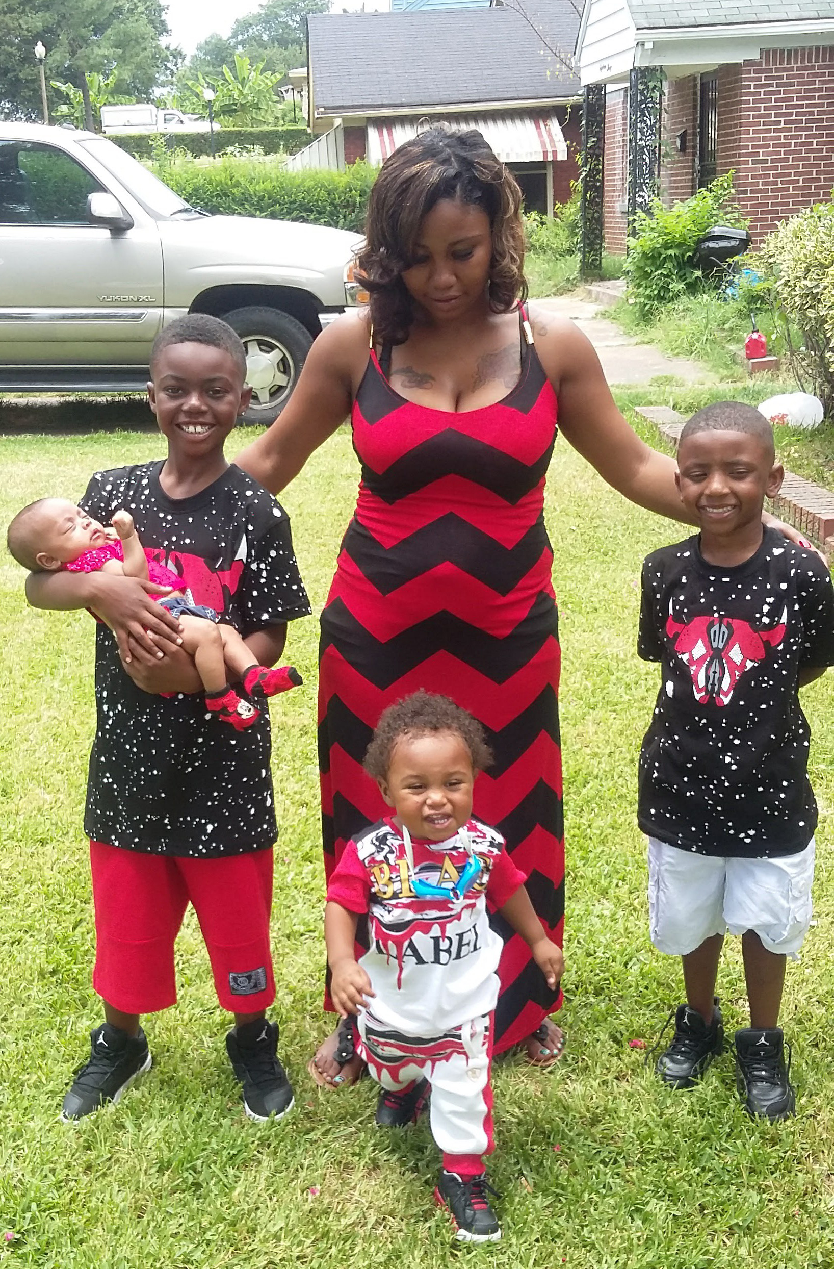Angel Latrice Burrell stands outside with her four young children. 