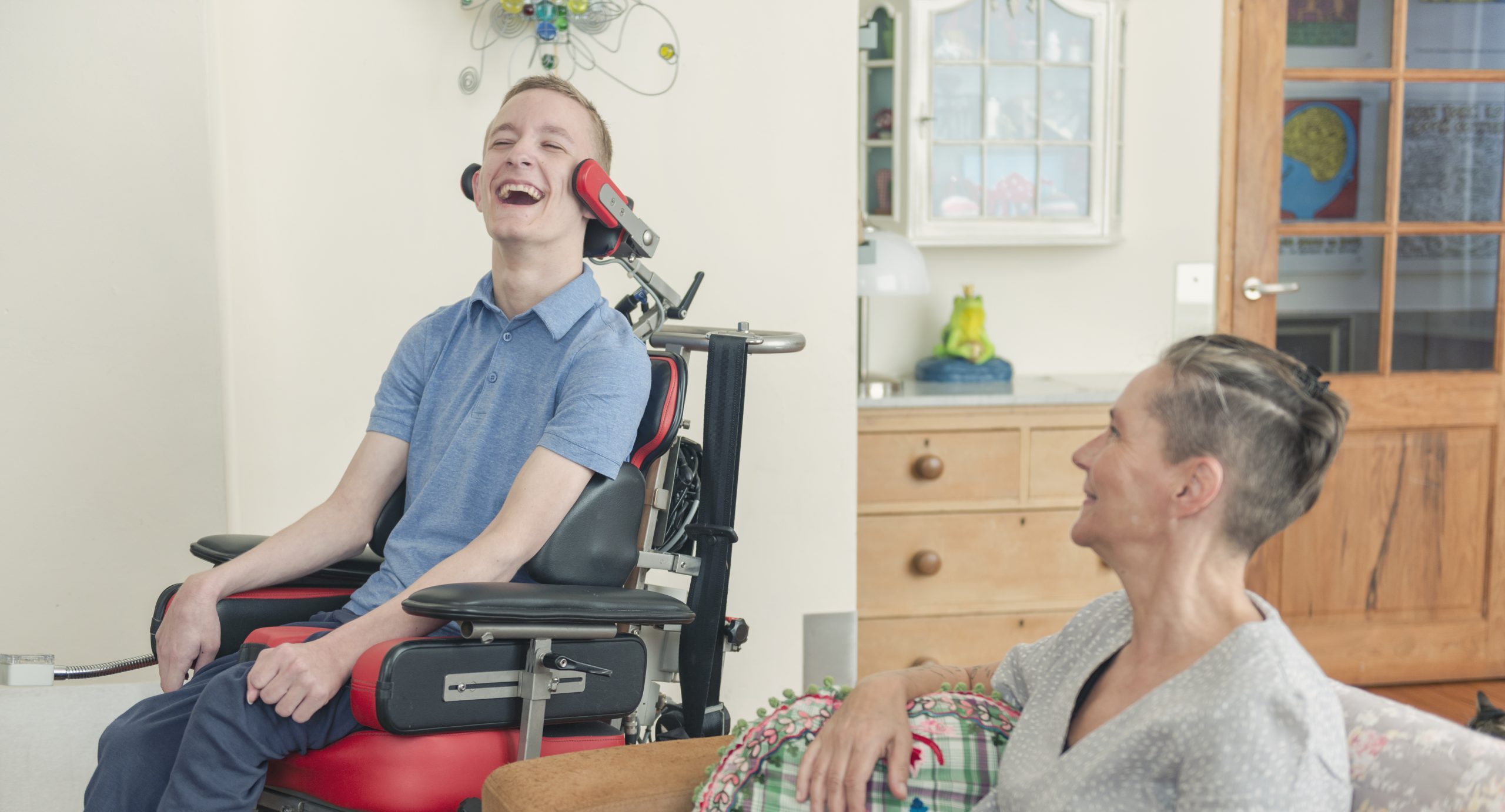 ALS patient in wheelchair sitting with a caregiver