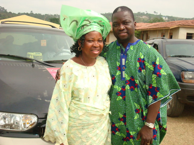 Nurse Adetoyi Olatilo with his mother, Olajumoke Olatilo. They are both wearing green and standing next to each other in a parking lot.