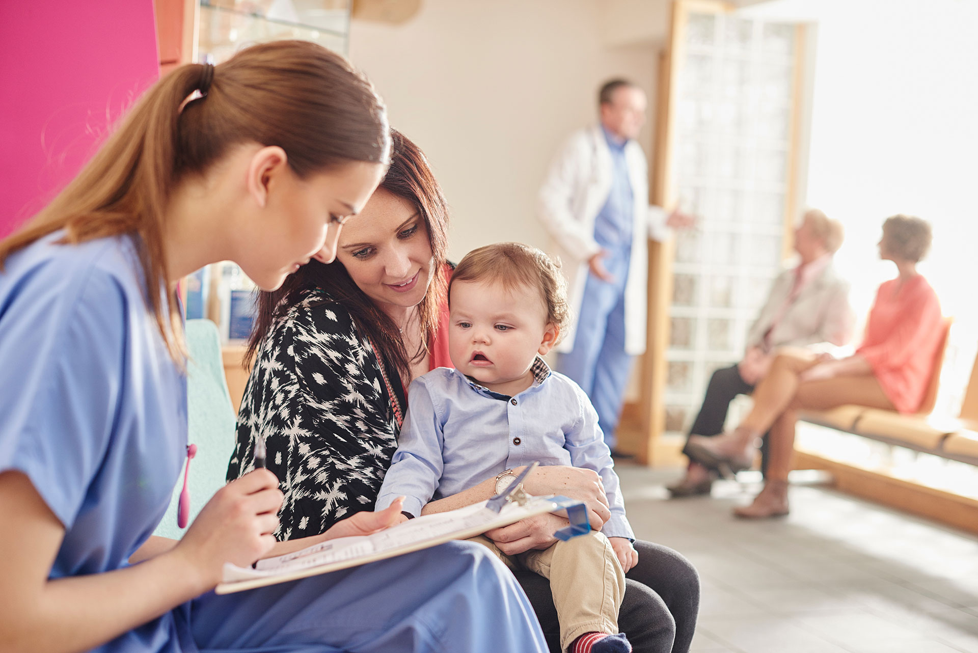 pediatric nurse speaks to child and mother