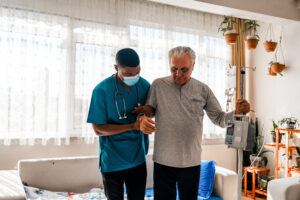 pdn nurse helps elderly man walk