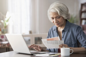 Older black women paying bills on a laptop