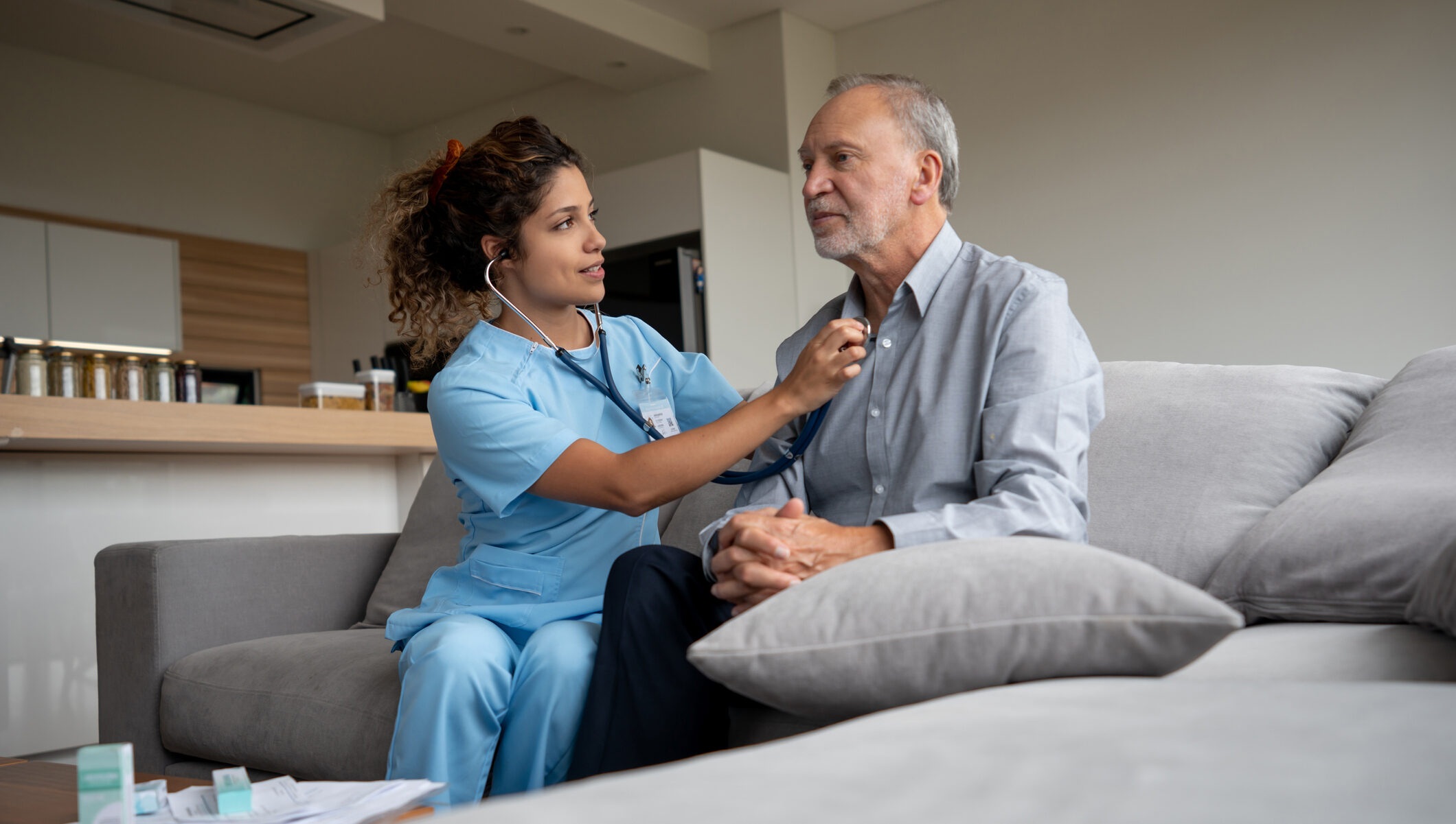 Home caregiver checking a senior man's vitals with a stethoscope