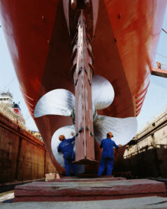 Men working on the propellor of a ship in dry deck 