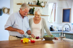 Smiling senior couple preparing a healthy lunch in their kitchen