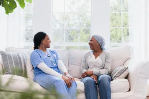 Smiling doctor and patient laugh together during a therapy session. Mental health, emotional support.