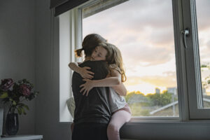 Young girl getting a big cuddle from her mother