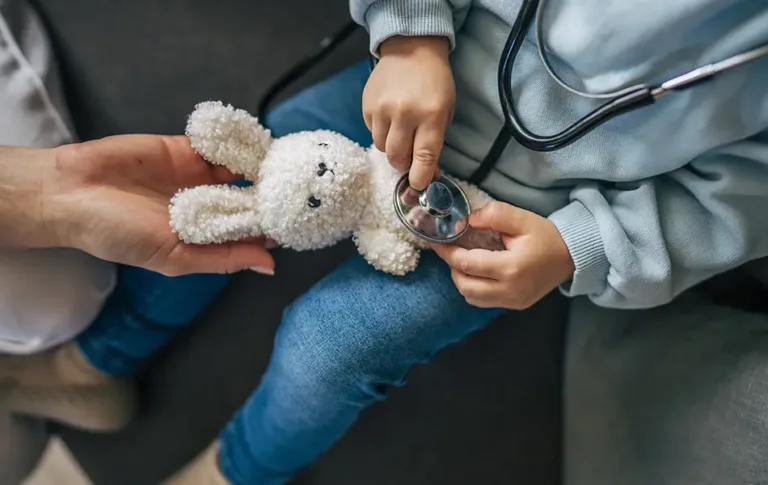 Child holding a stethoscope to a plush bunny toy — personalized pediatric private duty nursing (PDN) services from Maxim Healthcare.