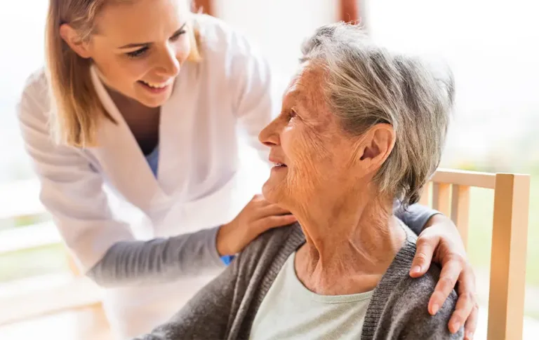 Happy caregiver interacting with a smiling elderly individual, representing Maxim Healthcare's respite care services.
