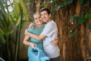 Woman and teenage boy embracing and smiling.